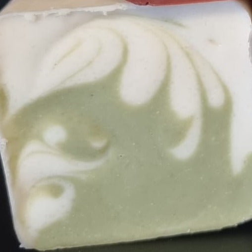 Natural cp soap made using glacial marine clay in part of the batter, with a swirl design that is white and mid green